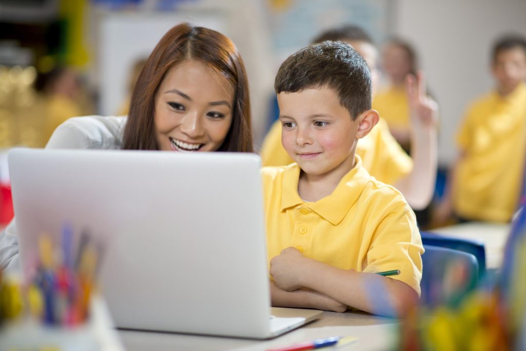 schoolboy with laptop and teacher
